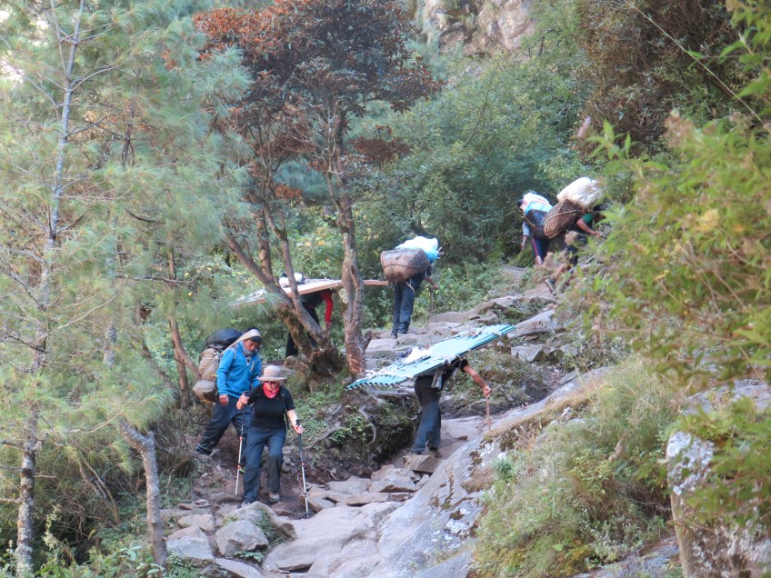 Porters carrying building materials up the trail